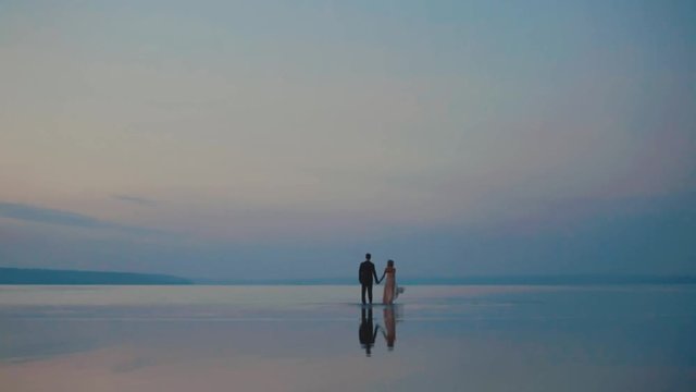 Large body of water. Tourism, ocean travel, Drone view - birds eye angle. Romantic young couple enjoying beautiful sunset walk on the beach travel vacation, Krabi Thailand