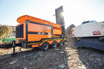 Excavator sorts plastic garbage at waste processing plant. Separate garbage collection. Recycling and storage of waste for further disposal. Business for sorting and processing of waste.