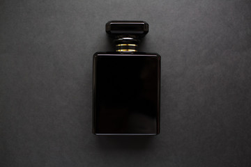 Close-up of black perfume bottle, isolated on black.