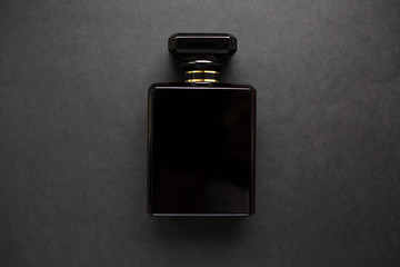 Close-up of black perfume bottle, isolated on black.