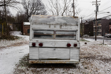 Back of a vintage mobile home trailer on snowy patch of ground