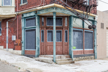Fototapeta na wymiar Corner entrance to an abandoned vintage building