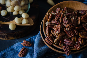 Variety of nuts: macadamia and pecan nuts in rustic style