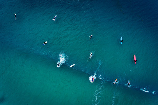 Aerial view of a group of surfers in the ocean at the Baleal beach in Peniche, Portugal