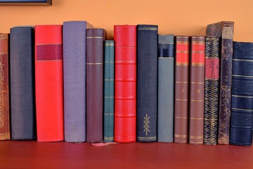 Old antique books background. The ancient books on an orange and claret  background