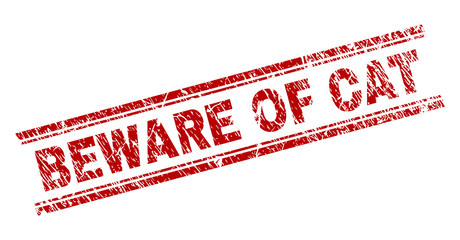 BEWARE OF CAT seal watermark with distress texture. Red vector rubber print of BEWARE OF CAT text with dirty texture. Text label is placed between double parallel lines.