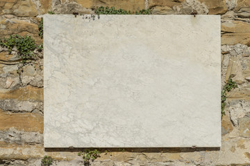 A blank marble sign on a wall in Italy.