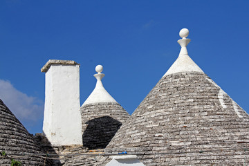 Fototapeta na wymiar le caratteristiche coperture a cono in pietra dei trulli, ad Alberobello