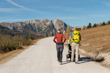 A man and woman with child in a pushchair  hiking in the Fanes Sennes Prags Nature Park near...