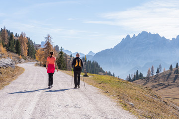 Obraz premium A man and woman hiking in the Fanes Sennes Prags Nature Park near Schluderbach Carbonin in the South Tyrol, Italy.