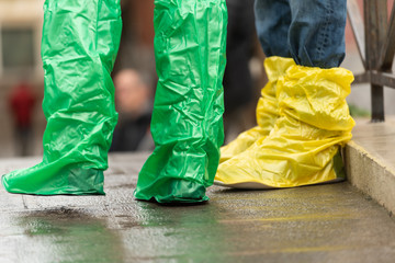 Coloured waterproof boots worn by tourists in Venice, Italy during a flood.