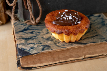 Tasty cupcakes decorated with chocolate and book loss. Dessert on a wooden table in the kitchen.
