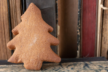 Tasty gingerbread and book loss. Dessert on a wooden table in the cabinet.