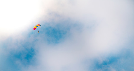 Parachutist in clouded sky