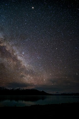 Beautiful milky way, starry night over the snow mountain at Lake Pukaki, New Zealand. High ISO Photography.