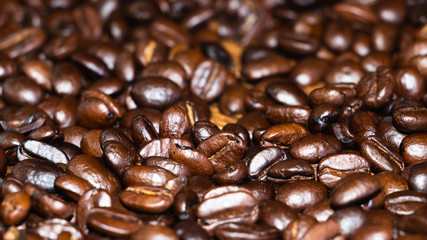 Fresh roasted dark coffee beans. Close up view of oily aromatic coffee.