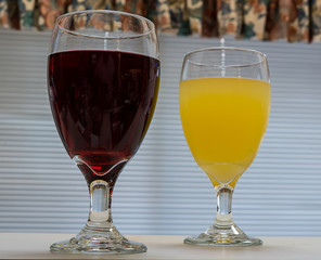 Two drinks on a counter in front of a window.
