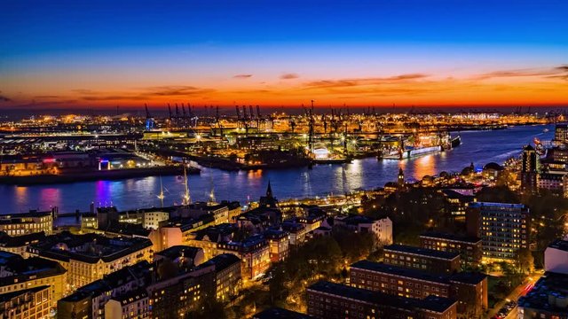 Aerial view of the harbor and harbor district, the river Elbe and downtown Hamburg, Germany. 4k UHD time lapse video at dusk.