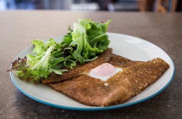 Filled with smoked ham, smoked salmon, grated cheese, sunny side up egg served with a green salad