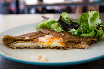 Filled with smoked ham, smoked salmon, grated cheese, sunny side up egg served with a green salad