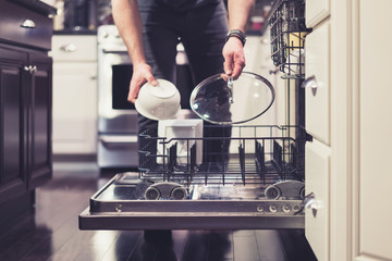 Man doing dishes cleaning in the kitchen household chores - obrazy, fototapety, plakaty