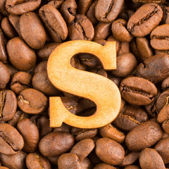 S, Letter of the alphabet on wood- background of coffee beans.