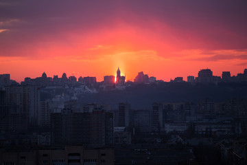 Fototapeta premium Sunset in Kiev, evening view of the panorama of the city, the church and the statue of the Motherland. Evening color urban landscape