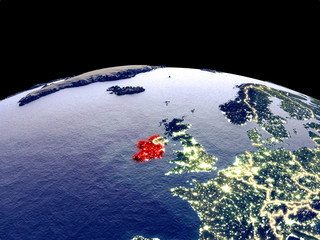 Ireland from space on planet Earth at night with bright city lights. Detailed plastic planet surface with real mountains.