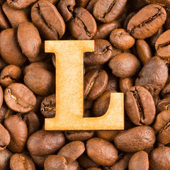 L, Letter of the alphabet on wood- background of coffee beans.