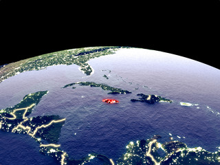 Jamaica from space on planet Earth at night with bright city lights. Detailed plastic planet surface with real mountains.