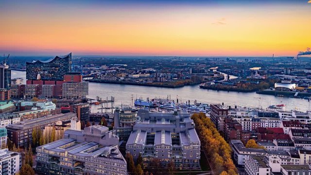 Aerial view of the harbor district, the concert hall "Elbphilharmonie" and downtown Hamburg, Germany. 4k UHD time lapse video at dusk with day to night transition.