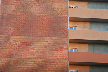brick wall of the house with balconies and windows