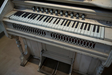 Partial angular topside view of painted antique pump organ