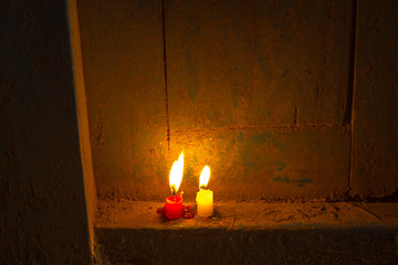 red and white glowing unburned candles on a wooden door at night