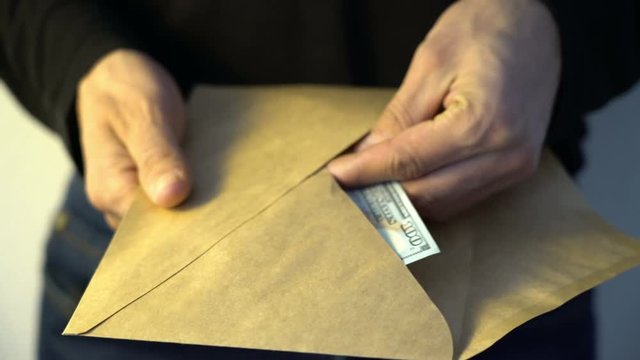 man getting out from envelope pile of american dollars money fraud crime corruption illegal corruption concept bribe