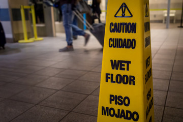 Yellow caution slippery wet floor sign isolated.