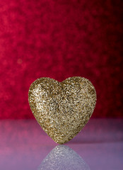 Gold heart over red background