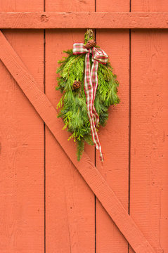 Traditional Evergreen Christmas Swag With Plaid Bow Hung On Pain