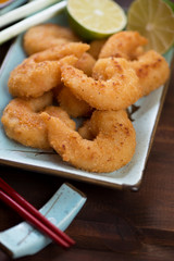 Close-up of japanese panko breaded shrimps on a turquoise plate, vertical shot, selective focus