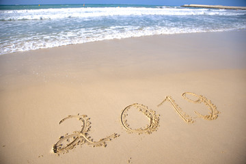 Year 2018 written at the sand beach