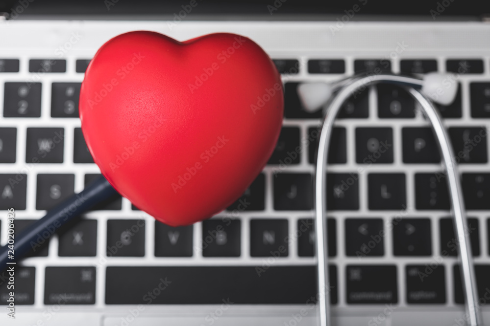 Poster health stethoscope and red heart on keyboard of laptop computer