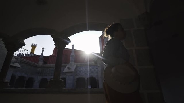 Side view young lady in casual wear looking away inside palace of Pena in city Sintra, Portugal 