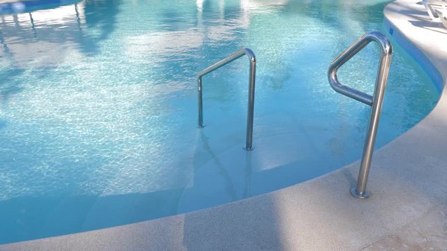 Grab bars ladder in swimming pool at poolside