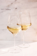 two white wine glasses on marble