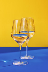 two wine glasses on blue and yellow