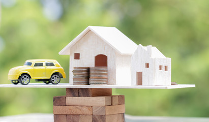 Business real estate investment concept : Wooden home, car with stack of money coins on wooden...