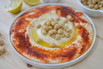 plate of Traditional  homemade hummus on rustic table background with red paprika olive oil ,garlic ,  lemon ,  tahini and  pita bread  Image
