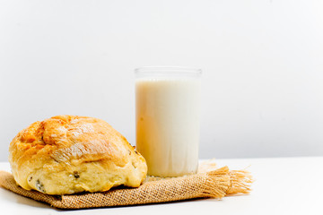 a glass of milk with bread and grains
