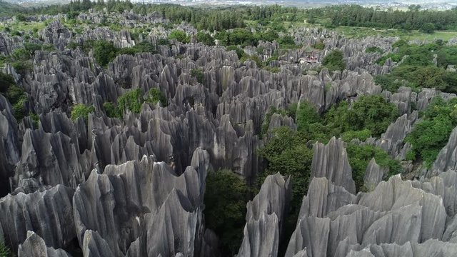 Drone shot flying over rock formations in Shilin Stone Forest, a popular geopark near Kunming in China