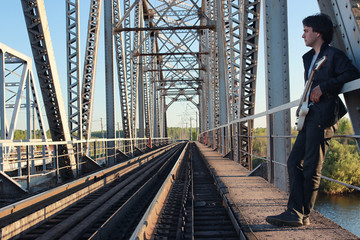 Man with an electric guitar in the industrial landscape outdoors